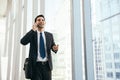 Man on smart phone - young business man in airport. Casual urban professional businessman using smartphone smiling happy. Royalty Free Stock Photo