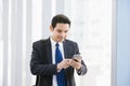 Man on smart phone - young businessman in airport. Casual urban professional business man using smartphone. Royalty Free Stock Photo