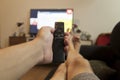 Man with smart TV remote control in hand, changing channel and watching streaming platform. Royalty Free Stock Photo