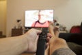 Man with smart TV remote control in hand, changing channel and watching streaming platform. Royalty Free Stock Photo