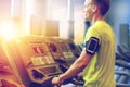 Man with smartphone exercising on treadmill in gym Royalty Free Stock Photo