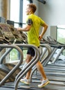 Man with smartphone exercising on treadmill in gym Royalty Free Stock Photo