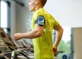 Man with smartphone exercising on treadmill in gym Royalty Free Stock Photo