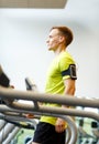 Man with smartphone exercising on treadmill in gym Royalty Free Stock Photo