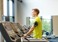 Man with smartphone exercising on treadmill in gym Royalty Free Stock Photo