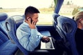 Man with smartphone and laptop in travel bus Royalty Free Stock Photo