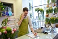 Man with smartphone making notes at flower shop Royalty Free Stock Photo