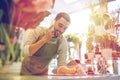 Man with smartphone making notes at flower shop Royalty Free Stock Photo