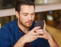 Man with smartphone reading message at restaurant Royalty Free Stock Photo