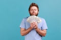 Man smelling earned dollar banknotes, enjoying success and big profit wealthy life, greedy for money Royalty Free Stock Photo