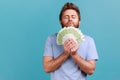 Man smelling earned euro banknotes, enjoying success and big profit, wealthy life, greedy for money. Royalty Free Stock Photo
