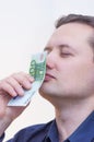 Man smelling money one hundred euros with closed eyes