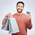 Man with smile, shopping bag and credit card with retail, discount and commercial isolated on white background. Customer