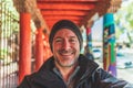 Man smiles at camera in foreground against dynamic orange red breezeway