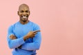 man smiling with folded arms pointing at copy space