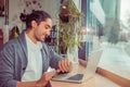 Man smiling looking to wristwatch while working at the computer Royalty Free Stock Photo