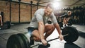 Man smiling while preparing to lift weights at the gym