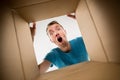 Man smiling, unpacking and opening carton box and looking inside Royalty Free Stock Photo