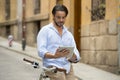 Man smiling using internet with digital tablet pad on vintage cool retro bike