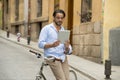 Man smiling using internet with digital tablet pad on vintage cool retro bike