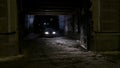 Man smokes hookah at car in alley. Action. Gangster view of young man smoking hookah on background of car headlights in