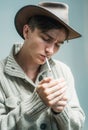 Man smoking cigar. Handsome man wear cowboy hat.