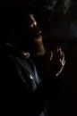 Man smoking cigarette isolated on black. A man smokes cannabis weed, a joint and a lighter in his hands. Smoke on black