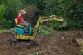 Man smoothing terrain with a mini digger
