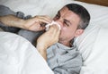 Man sneezing on the bed Royalty Free Stock Photo