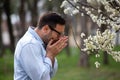 Man sneezing beside blooming tree Royalty Free Stock Photo