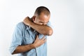 Man sneezing or coughing in his elbow to prevent spread the virus COVID-19 or Corona Virus on white background Royalty Free Stock Photo