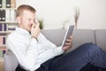 Man snickering to himself as he reads his tablet Royalty Free Stock Photo