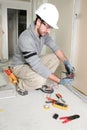 Man snipping wall wiring