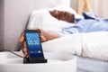 Man Snoozing Alarm On Mobile Phone