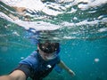 Man in snorkel mask doing selfie underwater. Adventure and travel concept.