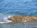 A man snorkeling with red diving fins in the sea in front of Pendennis Castle near Falmouth England