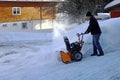 A man with a snow blower clears high snow Royalty Free Stock Photo