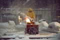 man with a snow blowing machine working and cleaning the city street in winter day during snow blizzard