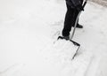 Man with snow shovel cleans sidewalks
