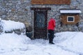 Man with snow shovel cleans sidewalks in winter near house. Winter time, snowfall. France Europe Royalty Free Stock Photo