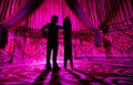 Man with snowboard inside Yurt nomadic house with pink light