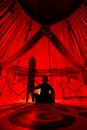 Man with snowboard inside Yurt nomadic house with red light