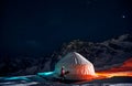 Man with snowboard near Yurt nomadic house at night at Mountains Royalty Free Stock Photo