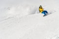 A man a snowboarder freerider descends a backcountry at high speed from a slope