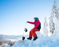 Man snowboarder sitting on top of a snowy hill with his snowboard enjoying stunning mountains view ski resort Royalty Free Stock Photo
