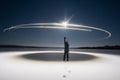 A man in a snowfield, the moon, footprints in the snow and a circle of light around