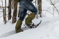 Man in snowshoes in the snow in the forest.