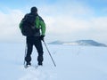 Man with snowshoes take a rest in snow. Hiker snowshoeing