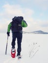 Man with snowshoes take a rest in snow. Hiker snowshoeing