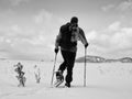 Man with snowshoes take a rest in snow. Hiker snowshoeing